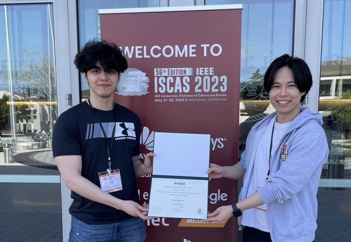Khayle and Xin outside ISCAS 2023 in Monterey, holding the IEEE award certificate